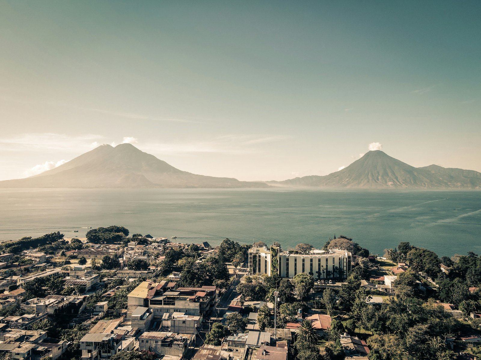 Aerial view over Panajachel and Lago de Atitlan with twin volcanic peaks rising across the water