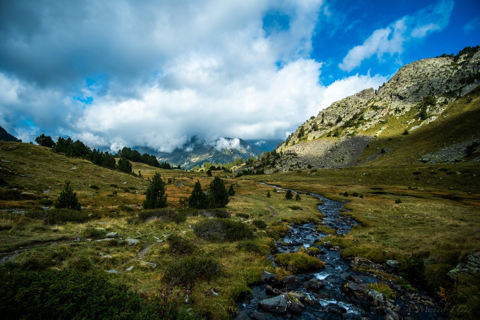 Mountain ridgeline with trees and clouds above the Catalan Pyrenees