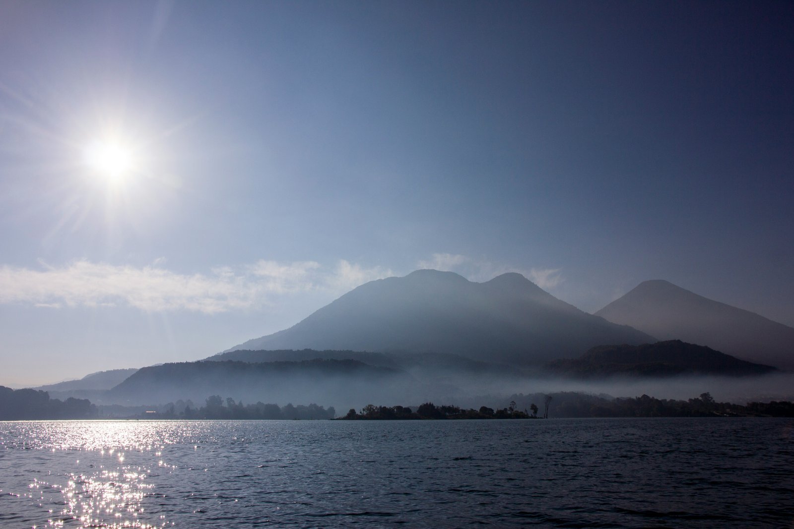 Morning mist over Lake Atitlan, volcanic peaks emerging from cloud