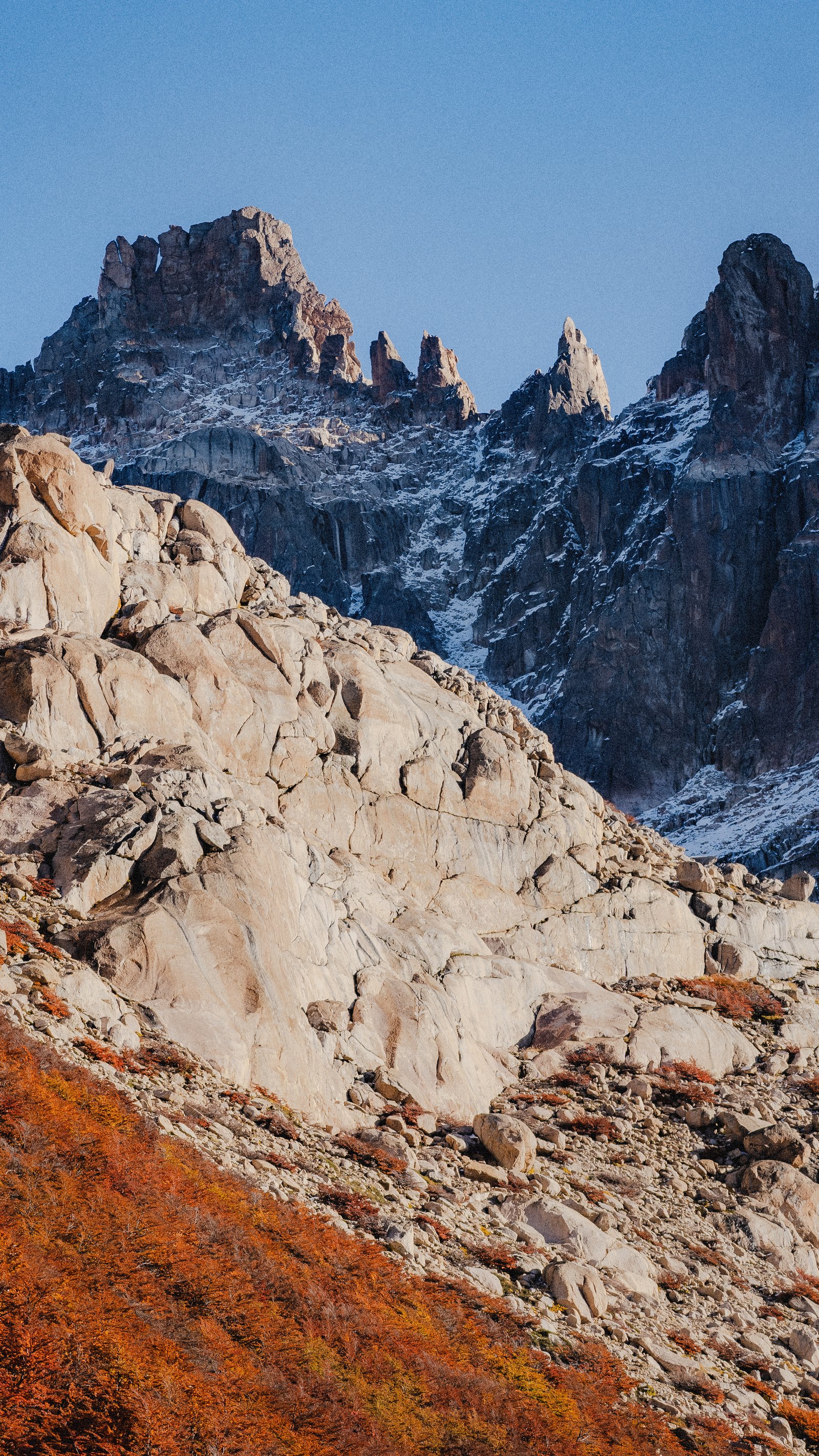 Moraine boulders at the cirque. The towers above through autumn haze.