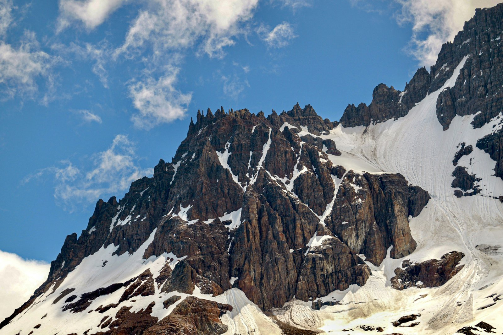 Jagged basalt crown of Cerro Castillo with ice and blue sky