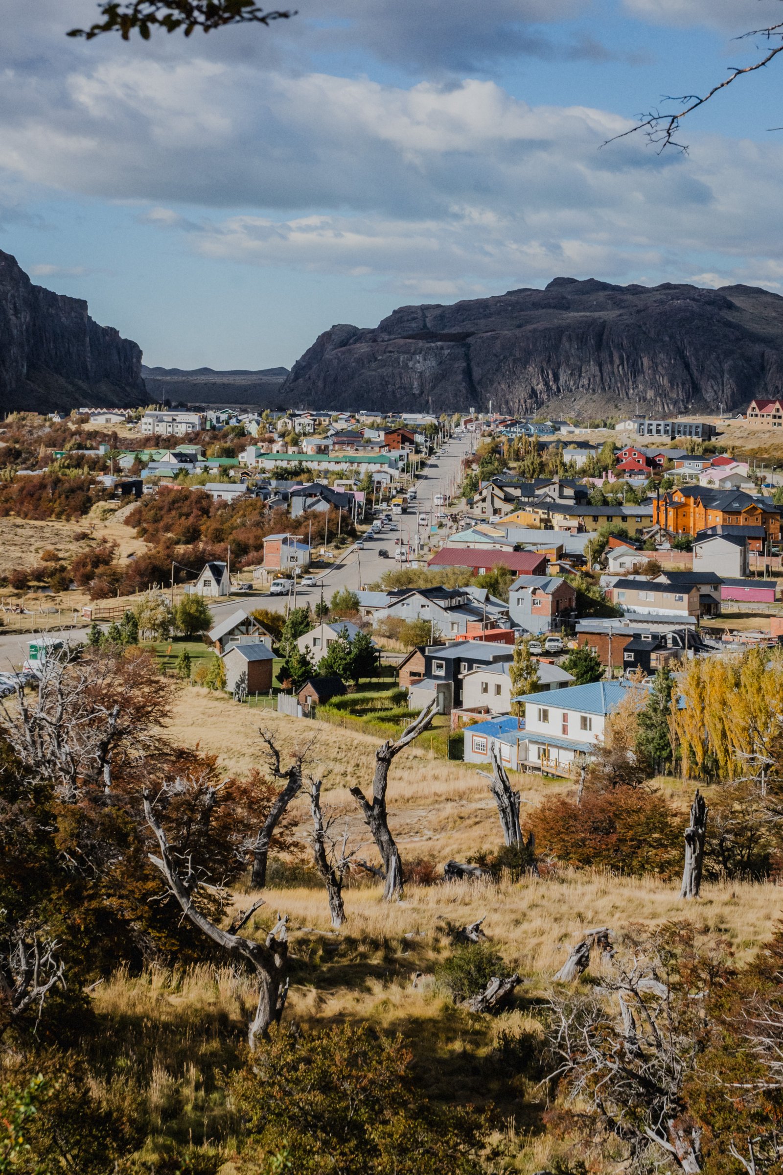 Bare lenga trees frame the rooftops. The valley opens behind.