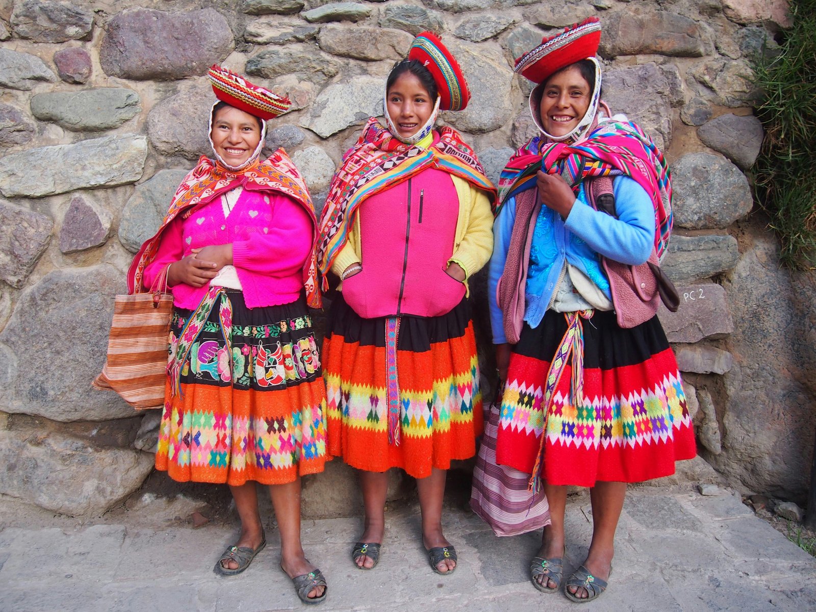 Three Quechua women in traditional colourful dress and embroidered skirts, Colca Valley