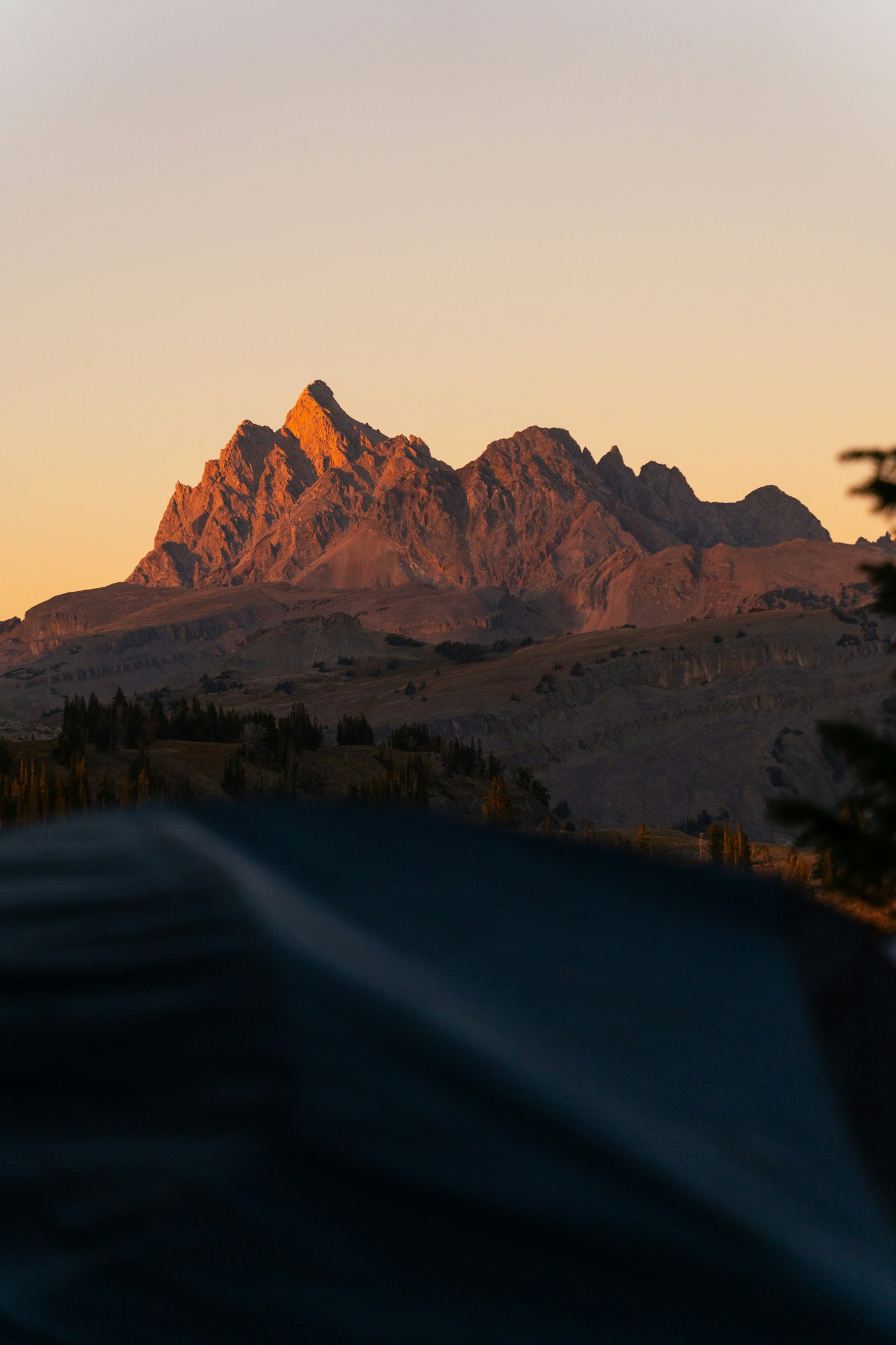 Jagged Teton peaks lit by golden hour light