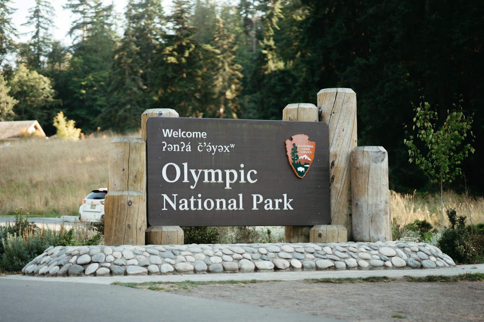 Olympic National Park welcome sign with mountains in the background