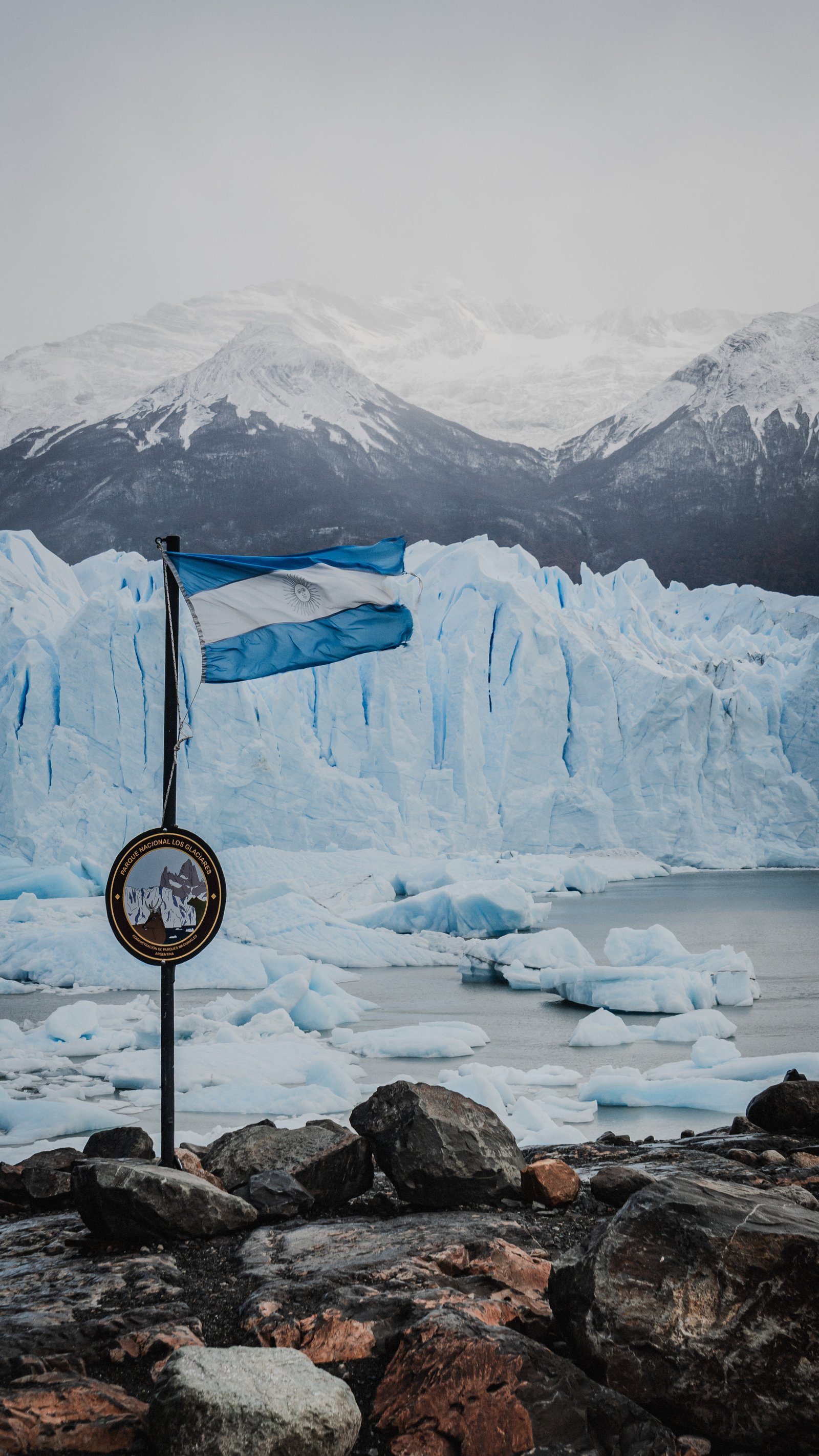 The Argentine flag against the glacier face. Los Glaciares National Park.