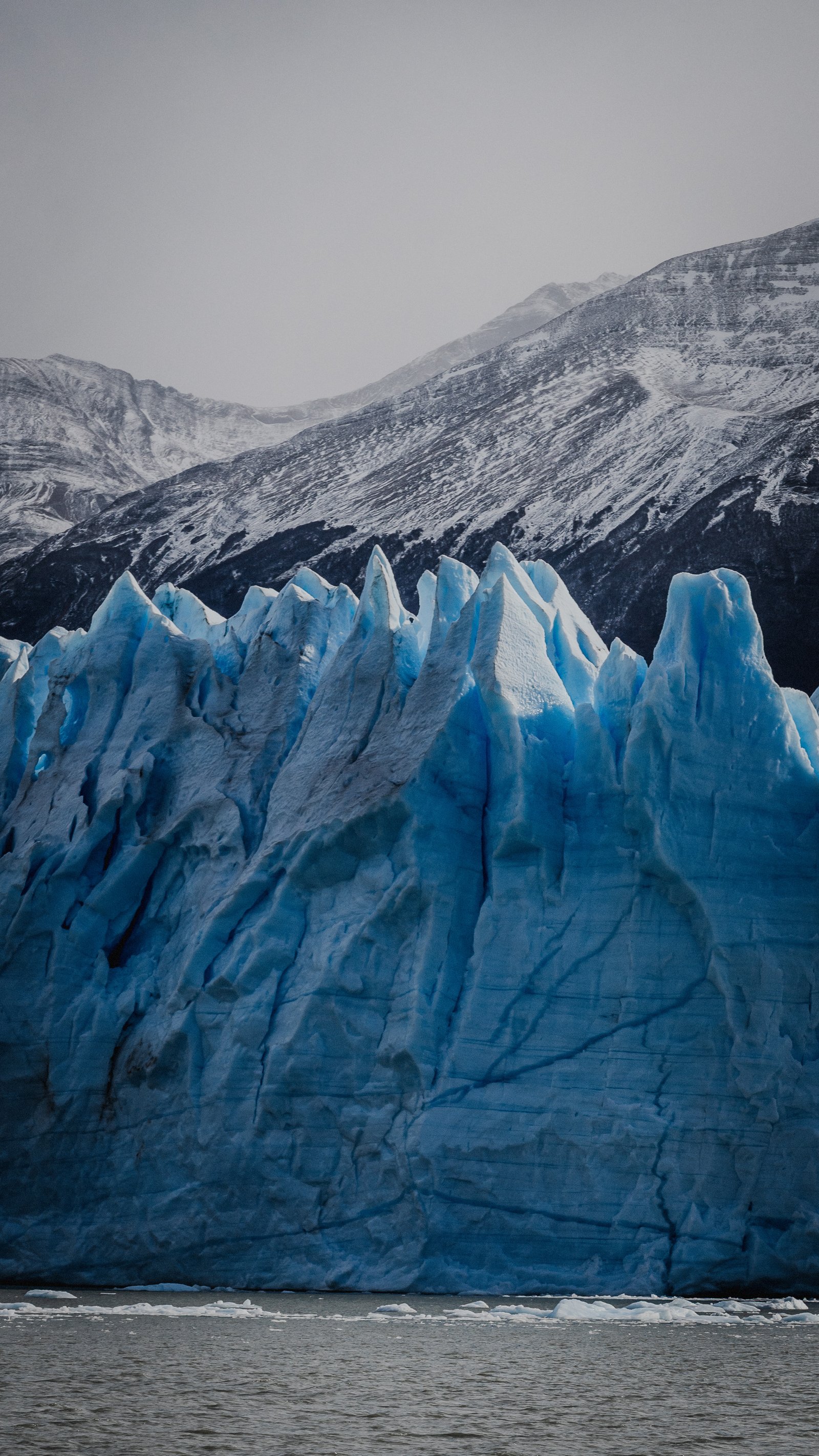Blue seracs rising from the glacier surface. Dark mountain behind.