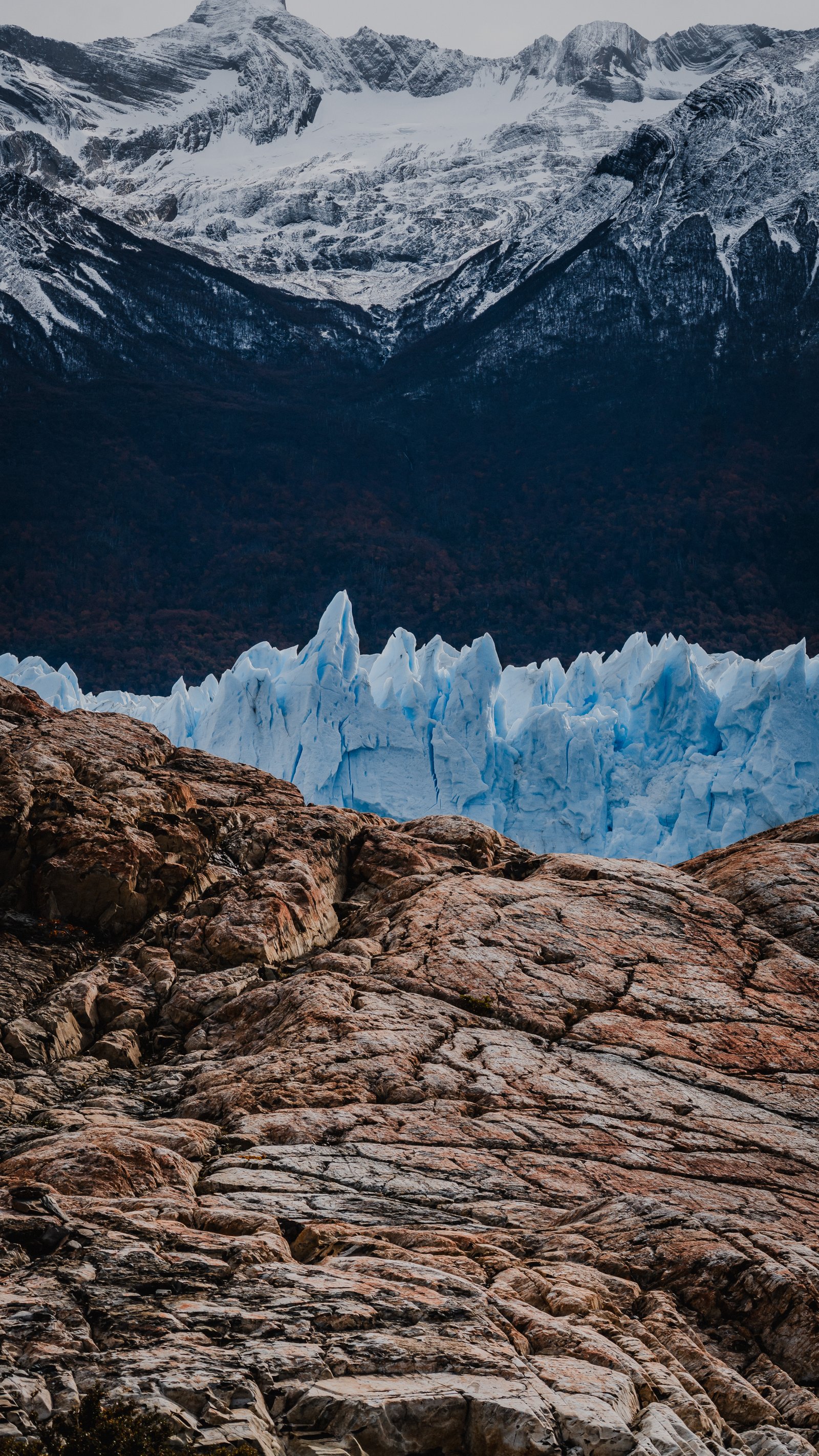 Orange rocks on the approach path. Glacier and snowy peaks beyond.