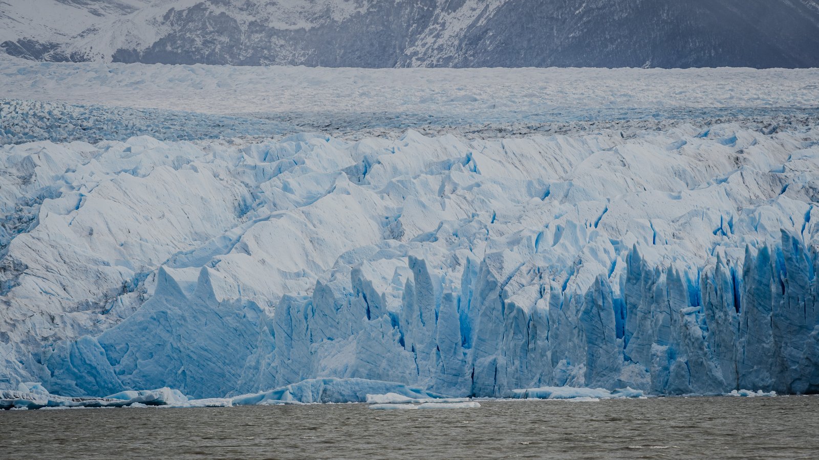 Textured ice face with blue seracs visible from the water.