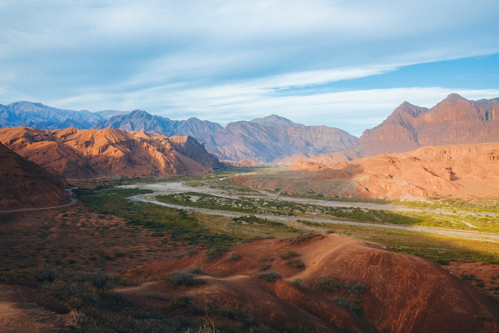 Meandering red river through the Quebrada de Humahuaca canyon at golden hour